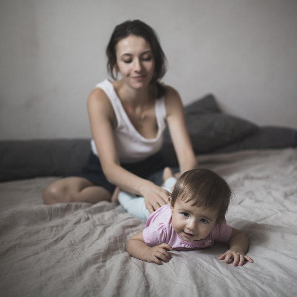 妈妈在给你的宝宝按摩。舒适的房子,生活方式,图片下载