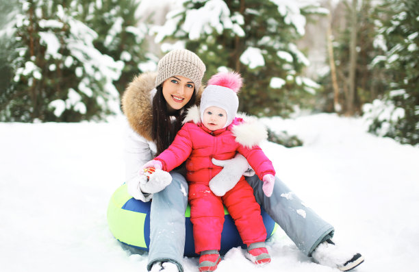 母亲和孩子在雪橇上玩在冬天图片下载