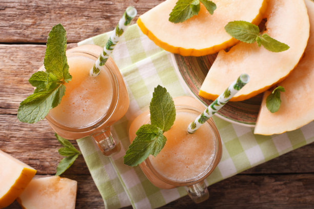 木桌上的杯子里有甜瓜汁图片下载