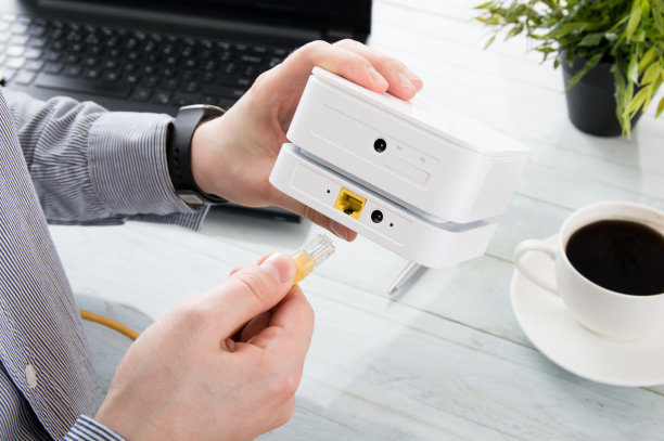 商人将他的笔记本电脑连接到移动WiFi路由器上素材图片