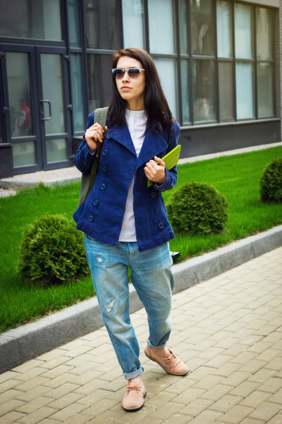 带着平板电脑的女学生走在办公楼附近图片下载