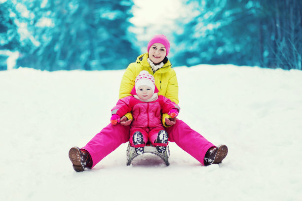 妈妈和孩子冬天玩雪橇素材图片
