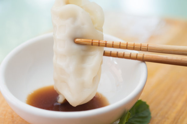 用筷子夹在木板上的饺子或饺子素材图片