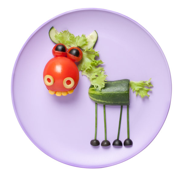用新鲜蔬菜做成的马，放在粉红色的盘子里图片下载