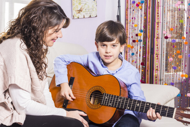 母亲和儿子一起弹吉他素材图片