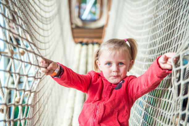 小女孩在游乐园的绳索隧道里图片下载