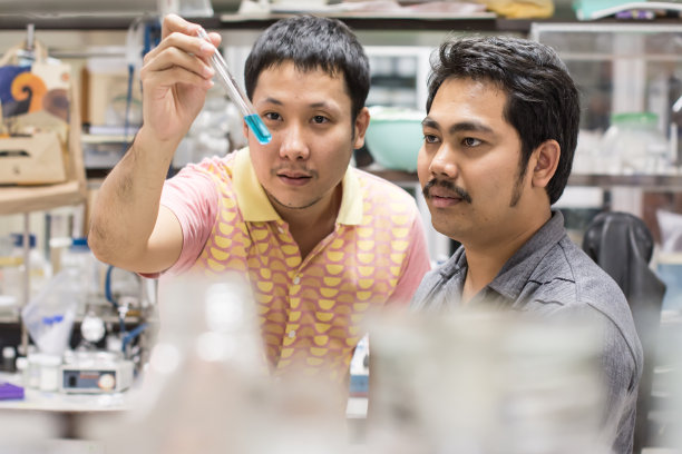 两个人在脏乱的实验室里研究化学品图片下载