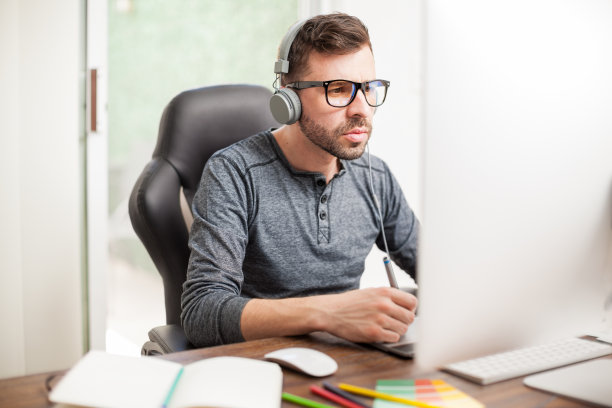 设计师在工作场所使用耳机图片下载