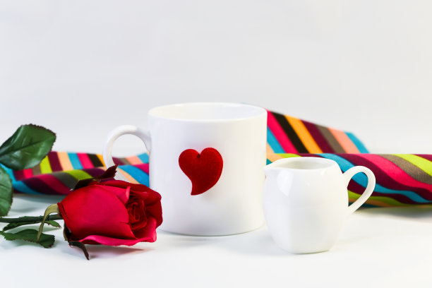 白色的杯子，红色的心和红玫瑰，孤立在白色的背景。图片下载