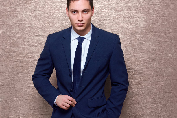 年轻的商人穿着蓝色西装，背景是闪亮的灰色图片下载