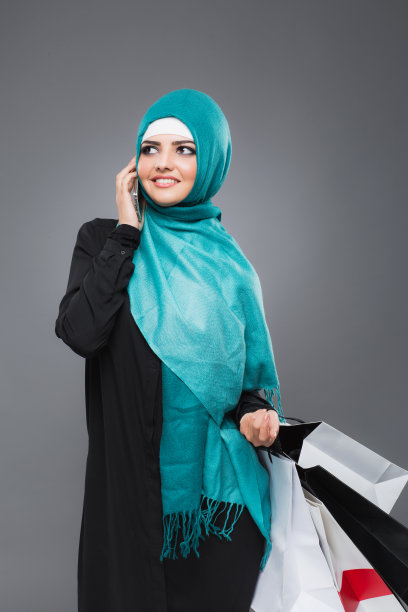 一名穆斯林妇女一边购物一边打电话图片下载
