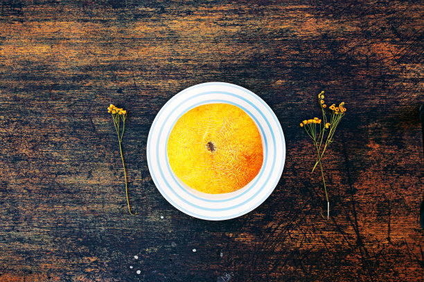 条纹盘上甜瓜和干洋甘菊。图片下载