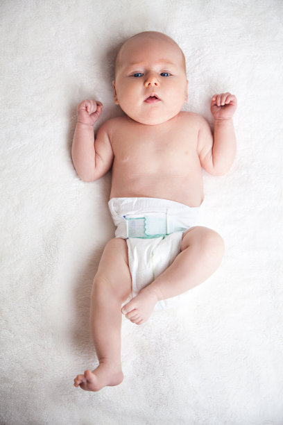 可爱快乐的小女孩在尿布躺和玩图片下载