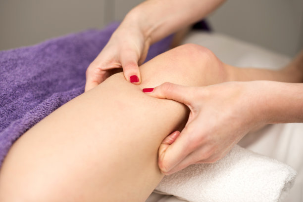 按摩师在美容院做腿部按摩，特写。图片下载