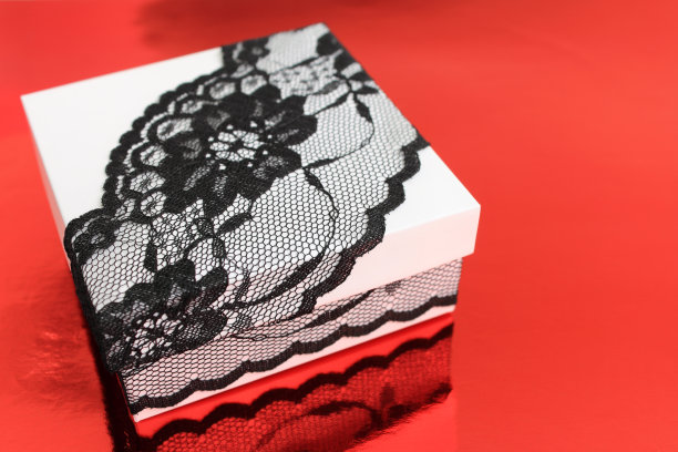 时尚的白色礼盒，饰以精致的黑色蕾丝丝带图片下载