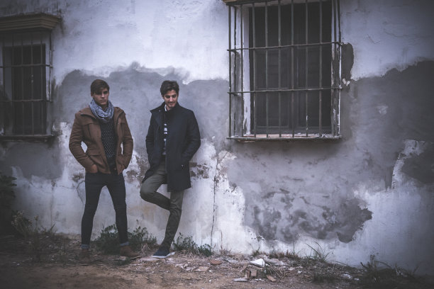 两个穿着时髦衣服摆姿势的年轻人的肖像图片下载