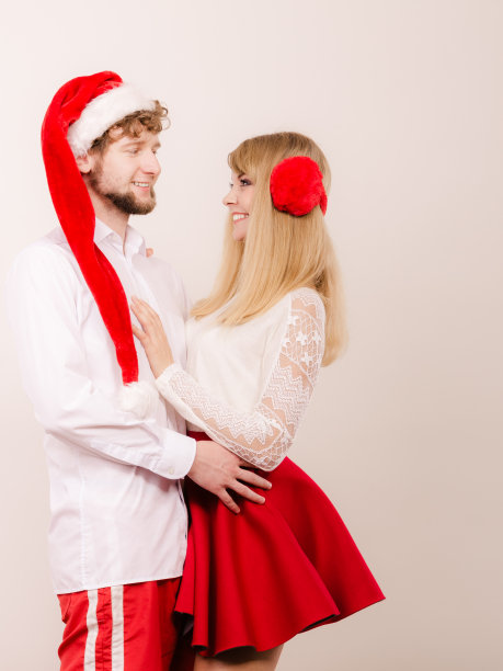 戴着圣诞老人帽微笑的夫妇。圣诞节。图片下载