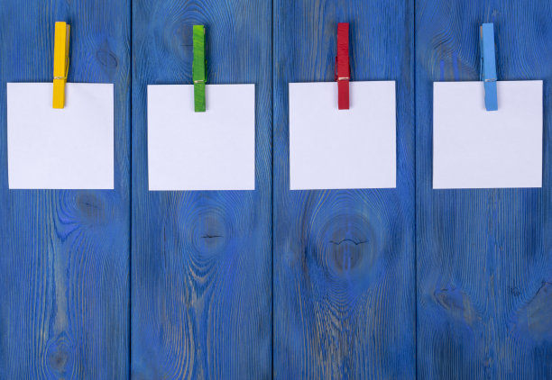 衣架上挂着空白的照片，木质的背景纹理图片下载