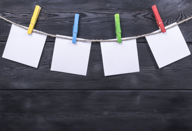 衣架上挂着空白的照片，木质的背景纹理图片下载