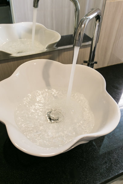 水在白色的洗涤盆里流动。图片下载