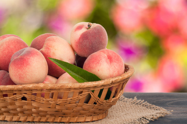 桃子装在柳条篮子里，放在木桌上模糊不清图片下载