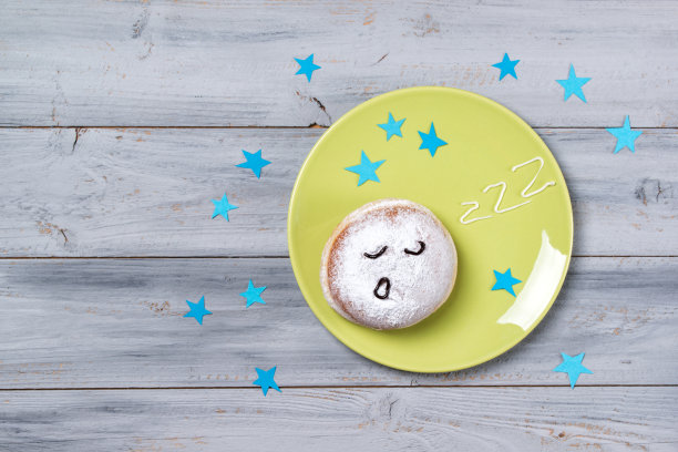 盘子里有瞌睡笑脸和呼呼的甜甜圈图片下载