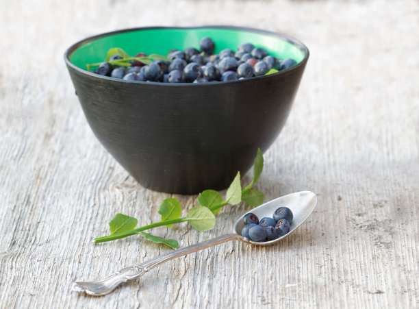 碗里的蓝莓和银勺。短的焦点图片下载