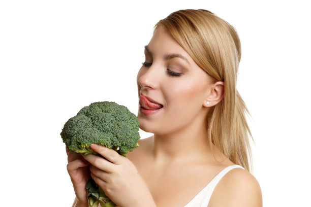 一个年轻漂亮的女人在吃花椰菜图片下载
