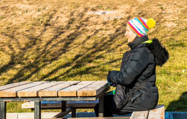 一个年轻女人独自坐在长椅上图片下载