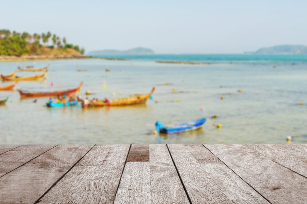 木桌面上泛着蓝色的大海和渔船图片下载