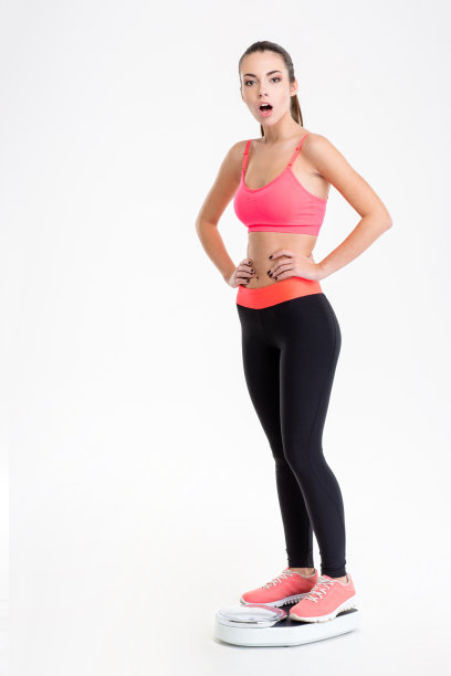 美丽的年轻健身女性站在体重秤上图片下载