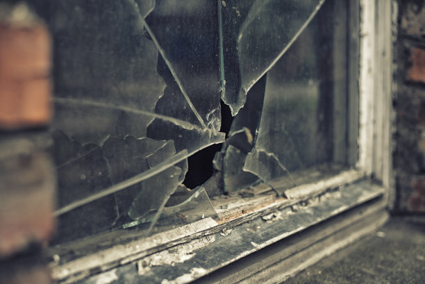 破碎的玻璃窗反射着浑浊的天空图片下载