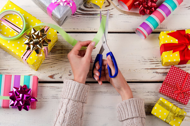 女人在家里包装现代圣诞礼物。素材图片