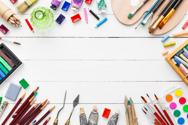 水彩和油画颜料，刷子，铅笔，蜡笔在桌子上。素材图片