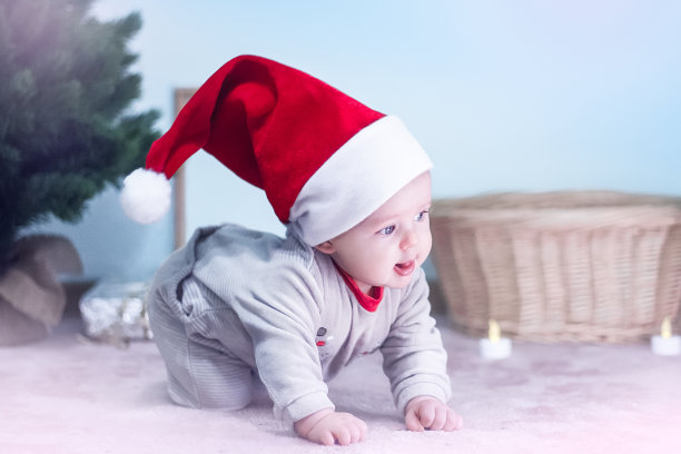 可爱的婴儿戴着圣诞帽庆祝圣诞节图片下载