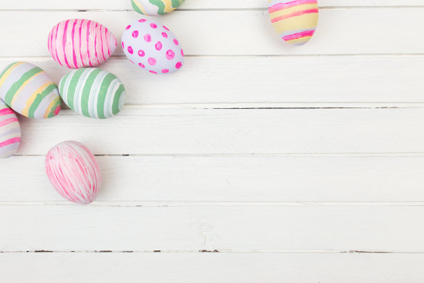 在白色的木头上用柔和的颜色画的复活节彩蛋图片下载