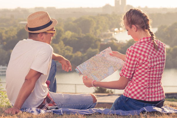 两个游客坐在山上看地图图片下载