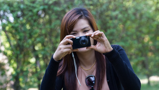 漂亮的年轻女子在户外拍照图片下载
