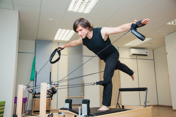 在普拉提设备上的男人。身体平衡图片下载