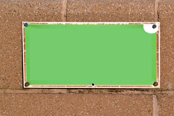 混凝土砌块墙上的空白绿色标志图片下载