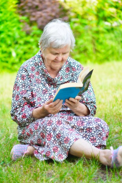 老妇人在公园看书。图片下载