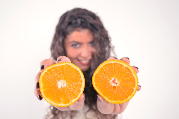 美丽的女孩拿着橘子图片下载