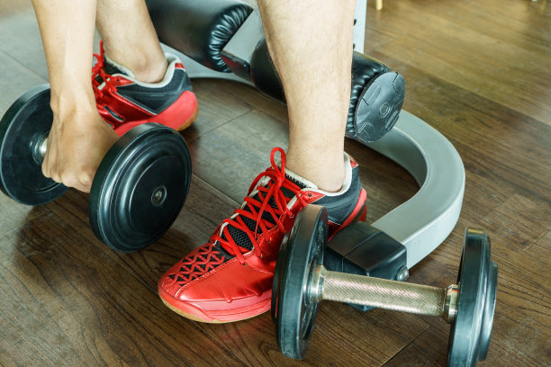 一只手在木地板上拿着哑铃图片下载