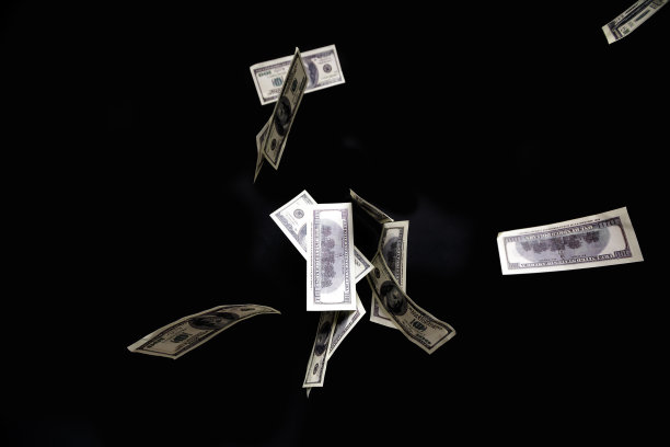 一百元钞票孤立地飞在黑色背景上。图片下载