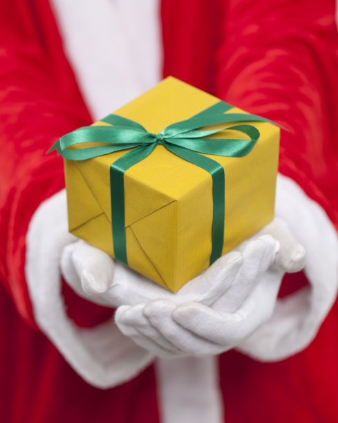 圣诞老人。他拿着一个黄色的盒子图片下载