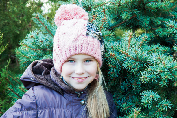 近距离肖像小女孩在冬天的云杉时间附近图片下载