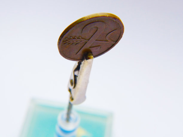 两枚欧分硬币放在鳄鱼夹支架上图片下载