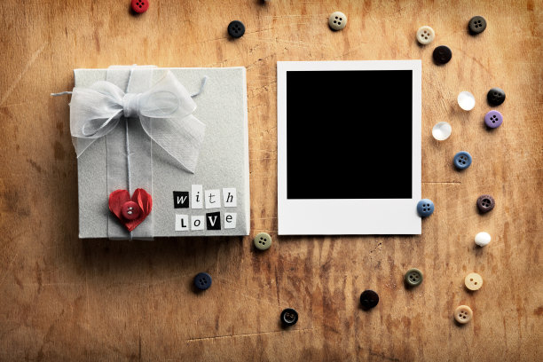 空白相框与礼盒在木头上。图片下载