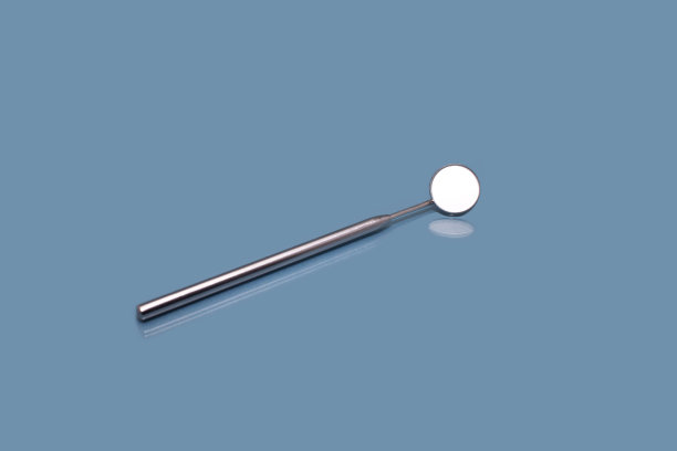 在蓝色背景上的牙科镜的特写图片下载