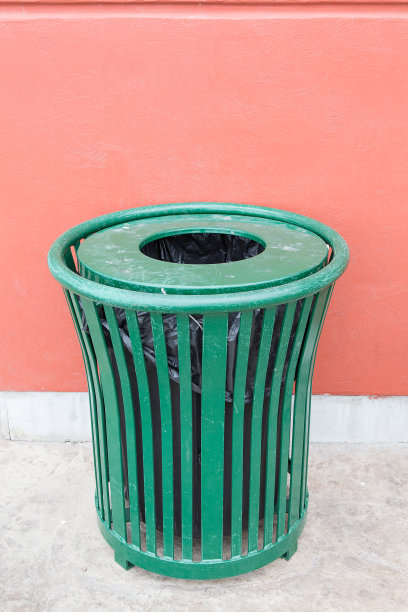 靠在墙上的绿色铁垃圾图片下载